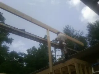 Carpenter setting a ridge beam over a new addition frame — Ice Dam Removal by Roofing Brothers in Alvarado