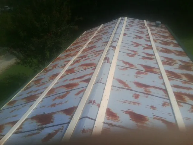 Rusted metal roof panels with new wood purlins before replacement — Storm Damage Roof Repair in Alvarado by Roofing Brothers