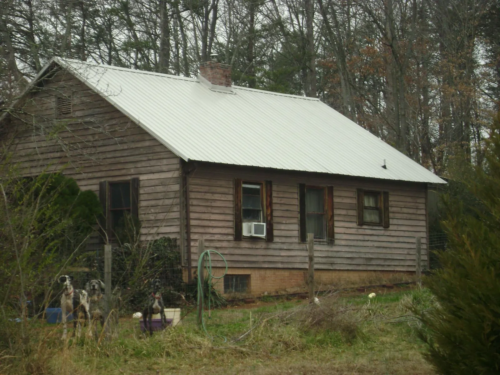 White metal roof on an old wood sided farmhouse, from a Metal Roof Installation job in Alvarado